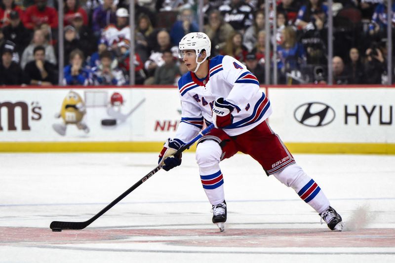 Nov 18, 2023; Newark, New Jersey, USA; New York Rangers defenseman Braden Schneider (4) skates with the puck during the third period against the New Jersey Devils at Prudential Center. Mandatory Credit: John Jones-USA TODAY Sports