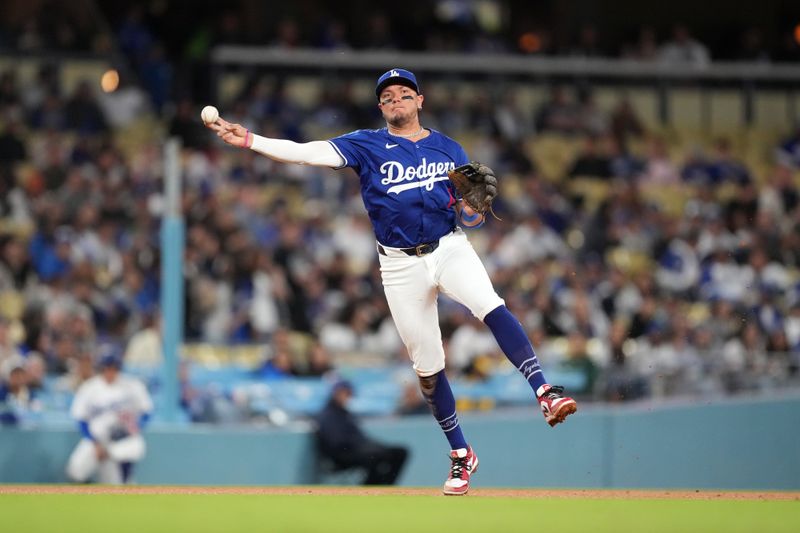 Mar 25, 2024; Los Angeles, California, USA; Los Angeles Dodgers shortstop Miguel Rojas (11) throws to first base in the fourth inning against the Los Angeles Angels at Dodger Stadium. Mandatory Credit: Kirby Lee-USA TODAY Sports