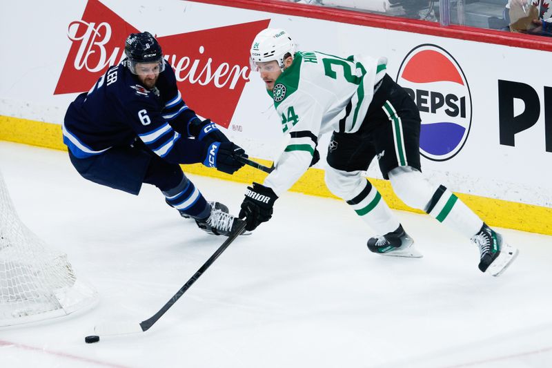 May 7, 2025; Winnipeg, Manitoba, CAN; Dallas Stars forward Roope Hintz (24) tries to skate away from Winnipeg Jets defenseman Colin Miller (6) during the third period in game one of the second round of the 2025 Stanley Cup Playoffs at Canada Life Centre. Mandatory Credit: Terrence Lee-Imagn Images