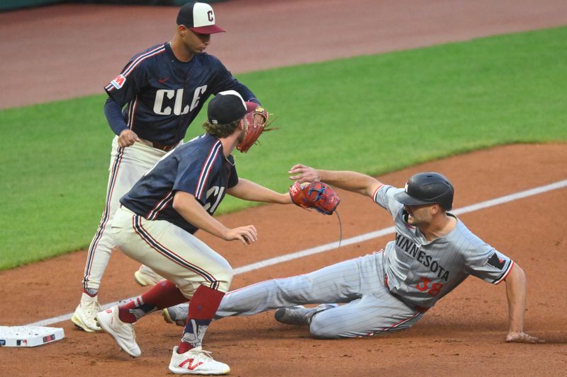 Sep 18, 2024; Cleveland, Ohio, USA; Minnesota Twins right fielder Matt Wallner (38) slides safely to third base beside Cleveland Guardians starting pitcher Tanner Bibee (28) and shortstop Brayan Rocchio (4) in the third inning at Progressive Field. Mandatory Credit: David Richard-Imagn Images