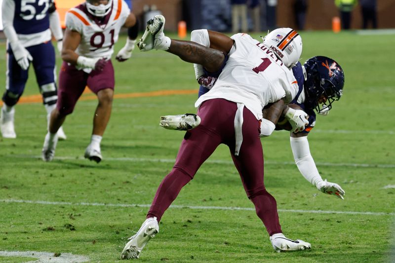 Nov 25, 2023; Charlottesville, Virginia, USA; Virginia Cavaliers wide receiver Malik Washington (4) is tackled by Virginia Tech Hokies cornerback Dante Lovett (1) during the third quarter at Scott Stadium. Mandatory Credit: Geoff Burke-USA TODAY Sports