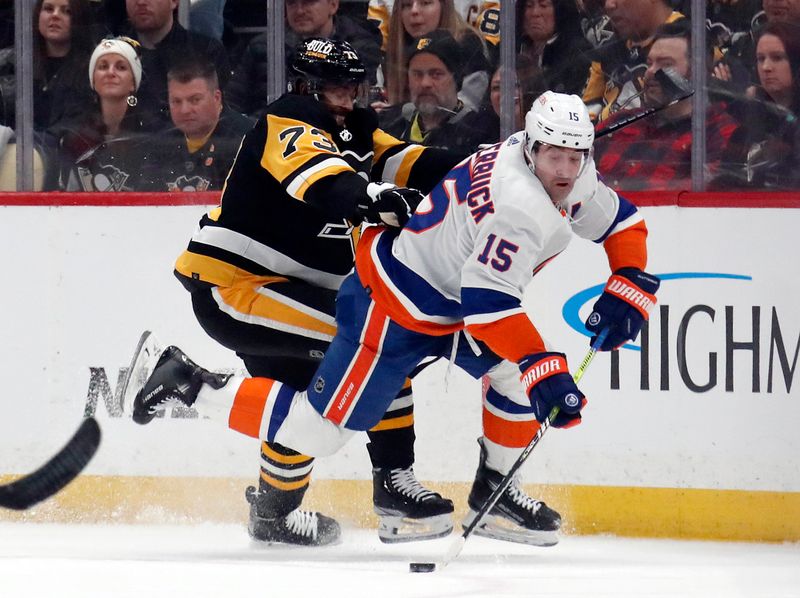 Feb 20, 2024; Pittsburgh, Pennsylvania, USA; Pittsburgh Penguins defenseman Pierre-Olivier Joseph (73) checks New York Islanders right wing Cal Clutterbuck (15) during the first period at PPG Paints Arena. New York won 5-4 in overtime. Mandatory Credit: Charles LeClaire-USA TODAY Sports