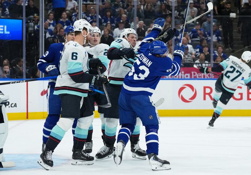 Oct 18, 2025; Toronto, Ontario, CAN; Seattle Kraken defenseman Vince Dunn (29) battles with Toronto Maple Leafs right wing Easton Cowan (53) during the first period at Scotiabank Arena. Mandatory Credit: Nick Turchiaro-Imagn Images