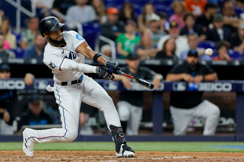 Jun 19, 2023; Miami, Florida, USA; Miami Marlins left fielder Bryan De La Cruz (14) hits a single against the Toronto Blue Jays during the fourth inning at loanDepot Park. Mandatory Credit: Sam Navarro-USA TODAY Sports