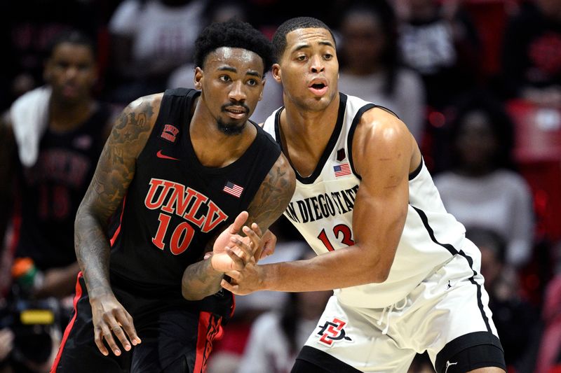 Jan 6, 2024; San Diego, California, USA; San Diego State Aztecs forward Jaedon LeDee (13) battles for position with UNLV Rebels forward Kalib Boone (10) during the second half at Viejas Arena. Mandatory Credit: Orlando Ramirez-USA TODAY Sports