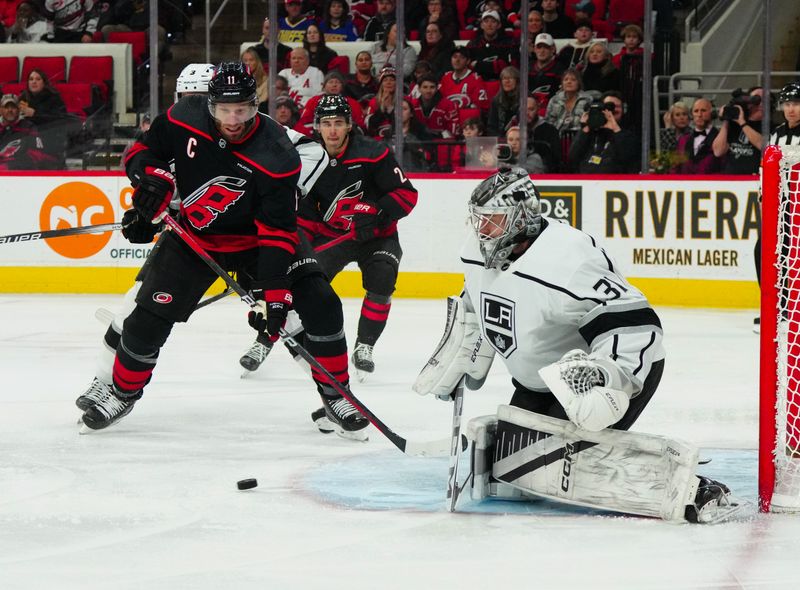 Jan 15, 2024; Raleigh, North Carolina, USA; Los Angeles Kings goaltender David Rittich (31) and Carolina Hurricanes center Jordan Staal (11) watch the shot during the first period at PNC Arena. Mandatory Credit: James Guillory-USA TODAY Sports