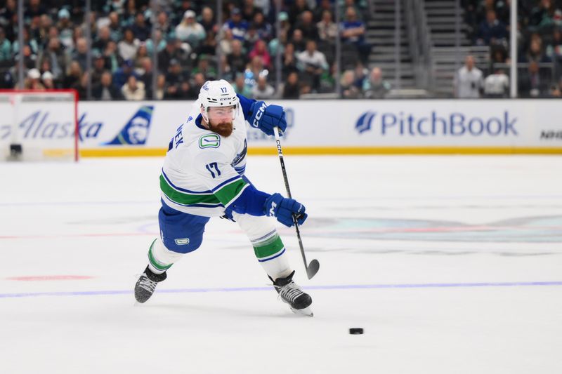 Feb 22, 2024; Seattle, Washington, USA; Vancouver Canucks defenseman Filip Hronek (17) shoots the puck against the Seattle Kraken during the third period at Climate Pledge Arena. Mandatory Credit: Steven Bisig-USA TODAY Sports