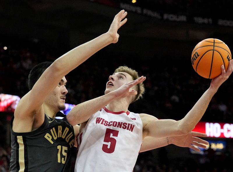 Mar. 2, 2023; Milwaukee, Wisconsin, USA; Wisconsin Badgers forward Tyler Wahl (5) shoots over Purdue Boilermakers center Zach Edey (15) during the second half of their game at Kohl Center. Mandatory Credit: Mark Hoffman-USA TODAY Sports
