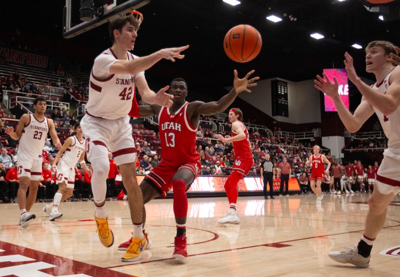 Jan 14, 2024; Stanford, California, USA; Stanford Cardinal forward Maxime Raynaud (42) passes away from defensive pressure by Utah Utes center Keba Keita (13) during the second half at Maples Pavilion. Mandatory Credit: D. Ross Cameron-USA TODAY Sports