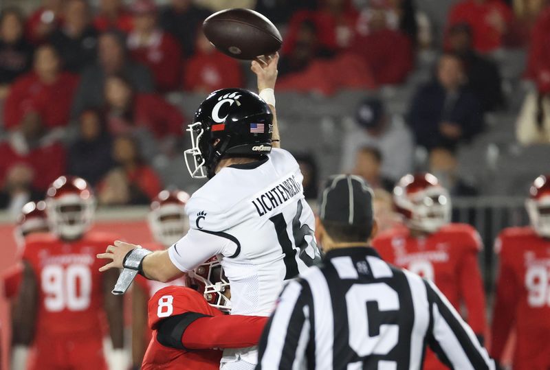 Nov 11, 2023; Houston, Texas, USA; Cincinnati Bearcats quarterback Brady Lichtenberg (16) passes as he is bit by Houston Cougars linebacker Malik Robinson (8) in the first half at TDECU Stadium. Mandatory Credit: Thomas Shea-USA TODAY Sports