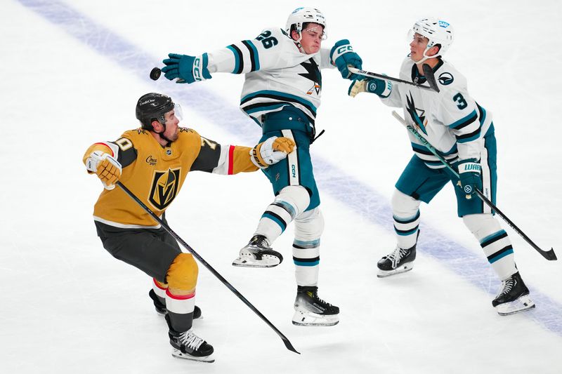 Oct 26, 2024; Las Vegas, Nevada, USA; San Jose Sharks defenseman Jack Thompson (26) bats down the puck between Vegas Golden Knights left wing Tanner Pearson (70) and San Jose Sharks defenseman Henry Thrun (3) during the third period at T-Mobile Arena. Mandatory Credit: Stephen R. Sylvanie-Imagn Images