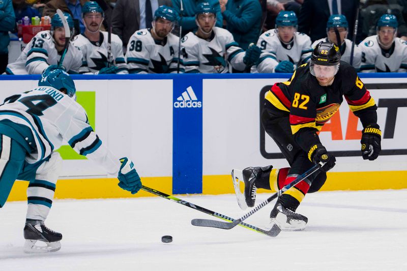 Dec 23, 2023; Vancouver, British Columbia, CAN; Vancouver Canucks defenseman Ian Cole (82) stick checks San Jose Sharks forward Mikael Granlund (64) in the third period at Rogers Arena. Canucks won 7-4. Mandatory Credit: Bob Frid-USA TODAY Sports