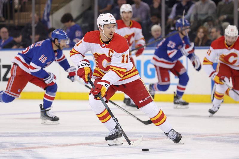 Feb 12, 2024; New York, New York, USA; Calgary Flames center Mikael Backlund (11) skates with the puck against the New York Rangers during the second period at Madison Square Garden. Mandatory Credit: Brad Penner-USA TODAY Sports