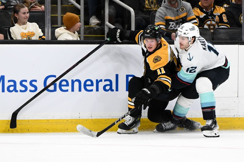 Nov 3, 2024; Boston, Massachusetts, USA; Boston Bruins center Trent Frederic (11) skates against Seattle Kraken left wing Tye Kartye (12) during the third period at the TD Garden. Mandatory Credit: Brian Fluharty-Imagn Images