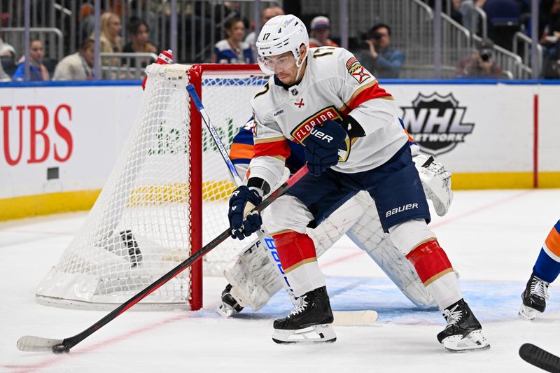 Oct 26, 2024; Elmont, New York, USA;  Florida Panthers center Evan Rodrigues (17) plays the puck in front of New York Islanders goaltender Semyon Varlamov (40) during the first period at UBS Arena. Mandatory Credit: Dennis Schneidler-Imagn Images