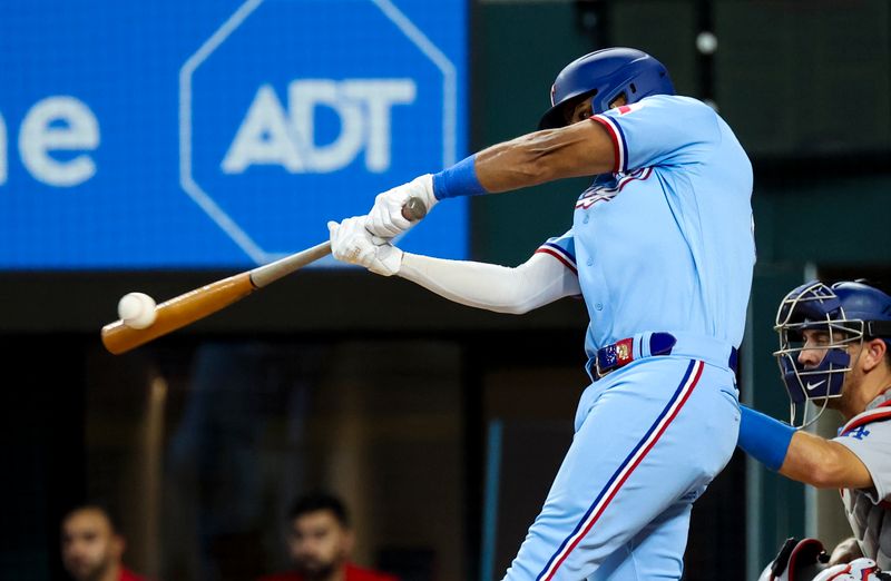 Jul 23, 2023; Arlington, Texas, USA;  Texas Rangers shortstop Ezequiel Duran (20) hits an rbi double during the fourth inning against the Los Angeles Dodgers at Globe Life Field. Mandatory Credit: Kevin Jairaj-USA TODAY Sports