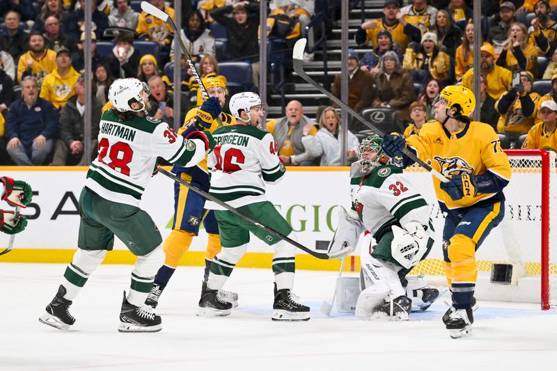 Feb 4, 2026; Nashville, Tennessee, USA;  Nashville Predators right wing Luke Evangelista (77) and Minnesota Wild right wing Ryan Hartman (38) battle for the puck during the third period at Bridgestone Arena. Mandatory Credit: Steve Roberts-Imagn Images