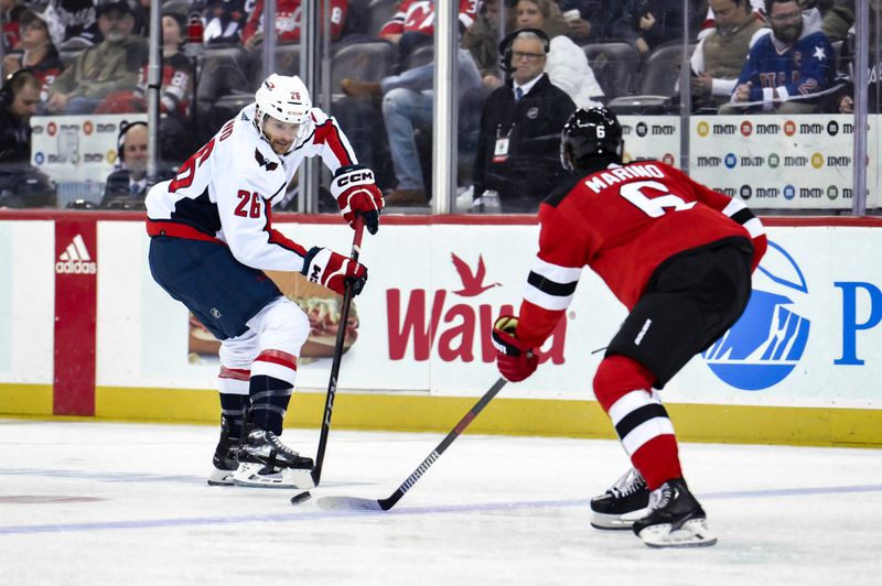 Nov 10, 2023; Newark, New Jersey, USA; Washington Capitals right wing Nic Dowd (26) skates with the puck against New Jersey Devils defenseman John Marino (6) during the third period at Prudential Center. Mandatory Credit: John Jones-USA TODAY Sports