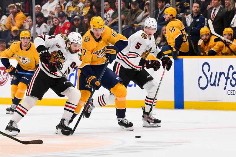 Jan 10, 2026; Nashville, Tennessee, USA;  Chicago Blackhawks left wing Landon Slaggert (84), defenseman Connor Murphy (5) and Nashville Predators right wing Michael McCarron (47) battle for the puck during the first period at Bridgestone Arena. Mandatory Credit: Steve Roberts-Imagn Images