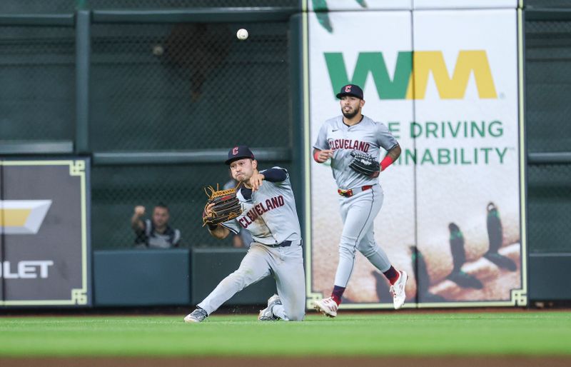 May 1, 2024; Houston, Texas, USA;  Cleveland Guardians left fielder Steven Kwan (38) throws from his knees after a catch to complete a double play to end the game tenth inning against the Houston Astros at Minute Maid Park. Mandatory Credit: Troy Taormina-USA TODAY Sports