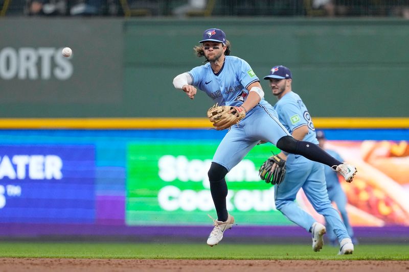 Jun 10, 2024; Milwaukee, Wisconsin, USA;  Toronto Blue Jays shortstop Bo Bichette (11) throws to first base during the second inning against the Milwaukee Brewers at American Family Field. Mandatory Credit: Jeff Hanisch-USA TODAY Sports