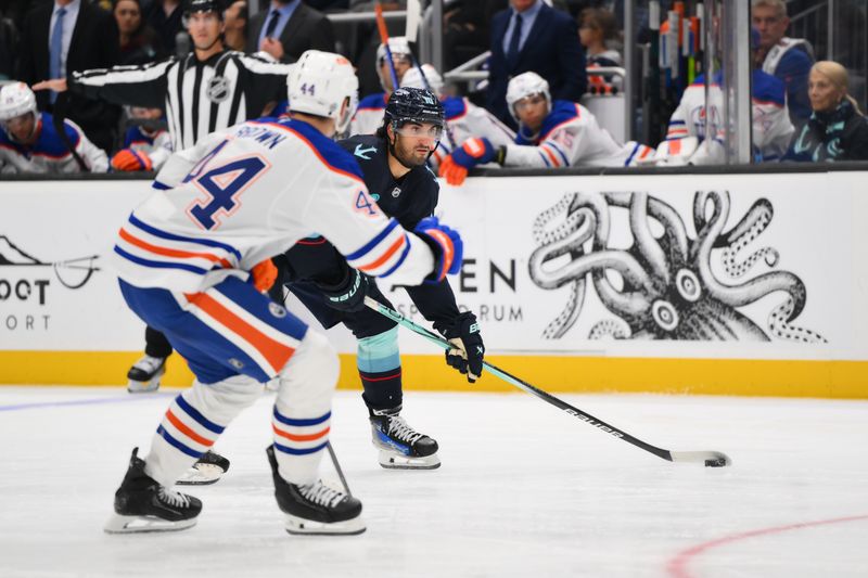 Oct 2, 2024; Seattle, Washington, USA; Seattle Kraken center Matty Beniers (10) advances the puck while defended by Edmonton Oilers defenseman Joshua Brown (44) during the third period at Climate Pledge Arena. Mandatory Credit: Steven Bisig-Imagn Images