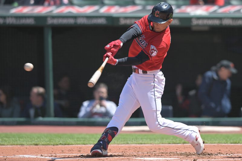 Apr 26, 2023; Cleveland, Ohio, USA; Cleveland Guardians second baseman Andres Gimenez (0) hits a single during the second inning against the Colorado Rockies at Progressive Field. Mandatory Credit: Ken Blaze-USA TODAY Sports