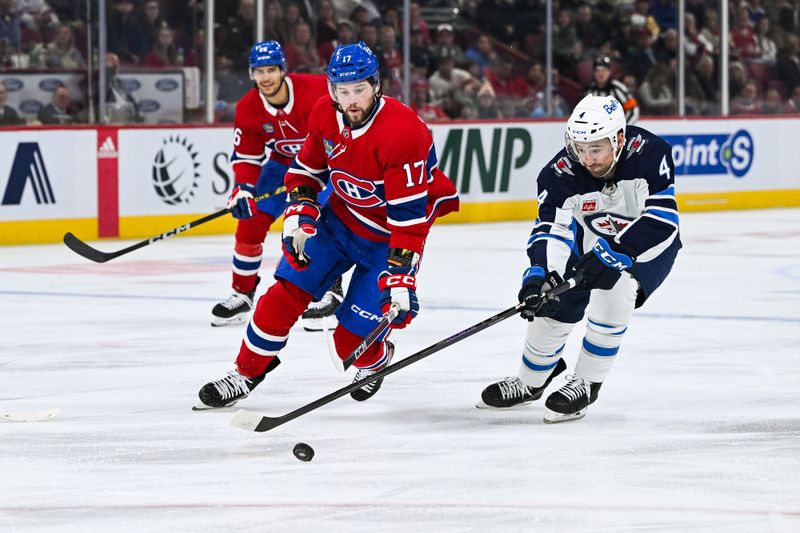 Oct 28, 2023; Montreal, Quebec, CAN; Winnipeg Jets defenseman Neal Pionk (4) defends against Montreal Canadiens right wing Josh Anderson (17) during the second period at Bell Centre. Mandatory Credit: David Kirouac-USA TODAY Sports