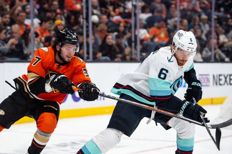 Oct 12, 2022; Anaheim, California, USA; Anaheim Ducks center Mason McTavish (37) and Seattle Kraken defenseman Adam Larsson (6) try to gain control of the puck during the second period at Honda Center. Mandatory Credit: Jonathan Hui-USA TODAY Sports