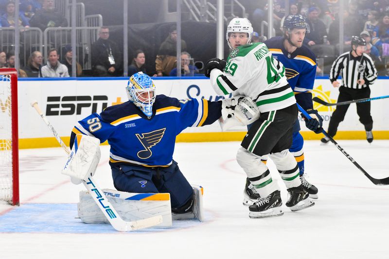 Jan 27, 2026; St. Louis, Missouri, USA; St. Louis Blues goaltender Jordan Binnington (50) defends the net against Dallas Stars center Justin Hryckowian (49) during the first period at Enterprise Center. Mandatory Credit: Jeff Curry-Imagn Images