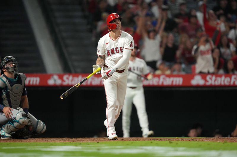 Aug 31, 2024; Anaheim, California, USA; Los Angeles Angels center fielder Mickey Moniak (16) hits a walk-off home run in the ninth inning as Seattle Mariners catcher Cal Raleigh (29) watches at Angel Stadium. Mandatory Credit: Kirby Lee-USA TODAY Sports