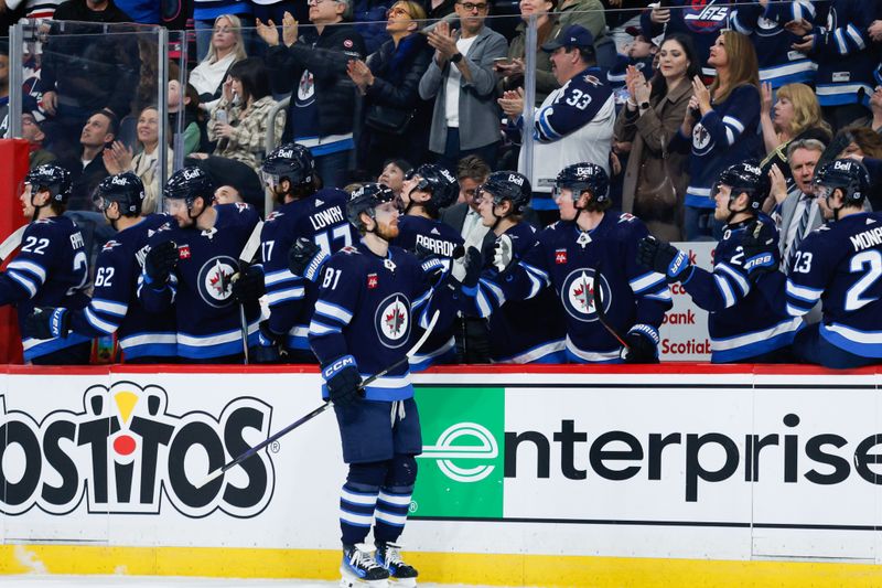 Mar 15, 2024; Winnipeg, Manitoba, CAN; Winnipeg Jets forward Kyle Connor (81) is congratulated by his team mates on his goal against the Anaheim Ducks during the first period at Canada Life Centre. Mandatory Credit: Terrence Lee-USA TODAY Sports