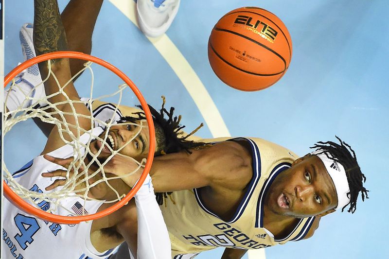 Dec 10, 2022; Chapel Hill, North Carolina, USA; North Carolina Tar Heels guard R.J. Davis (4) and Georgia Tech Yellow Jackets forward Jordan Meka (23) fight for the ball in the second half at Dean E. Smith Center. Mandatory Credit: Bob Donnan-USA TODAY Sports