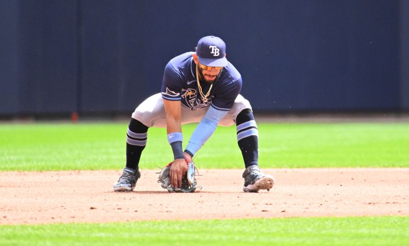 May 1, 2024; Milwaukee, Wisconsin, USA; Tampa Bay Rays shortstop José Caballero (7) fields the ball and throws to first base against the Milwaukee Brewers in the second inning at American Family Field. Mandatory Credit: Michael McLoone-USA TODAY Sports
