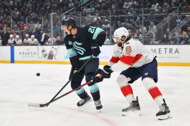 Mar 15, 2026; Seattle, Washington, USA; Seattle Kraken center Ryan Winterton (26) plays the puck while defended by Florida Panthers defenseman Aaron Ekblad (5) during the first period at Climate Pledge Arena. Mandatory Credit: Steven Bisig-Imagn Images