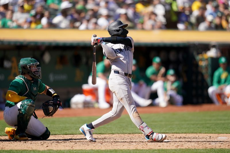 Sep 22, 2024; Oakland, California, USA; New York Yankees third baseman Jazz Chisholm Jr. (13) hits a sacrifice fly against the Oakland Athletics in the fifth inning at the Oakland-Alameda County Coliseum. Mandatory Credit: Cary Edmondson-Imagn Images