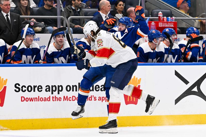 Jan 27, 2024; Elmont, New York, USA; Florida Panthers center Kevin Stenlund (82) checks New York Islanders right wing Cal Clutterbuck (15) during the second period at UBS Arena. Mandatory Credit: Dennis Schneidler-USA TODAY Sports