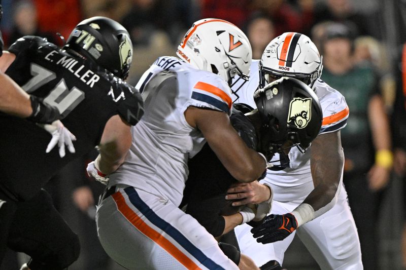 Nov 9, 2023; Louisville, Kentucky, USA; Virginia Cavaliers defensive end Paul Akere (1) defensive end Ben Smiley III (10) sack Louisville Cardinals quarterback Jack Plummer (13) during the second half at L&N Federal Credit Union Stadium. Louisville defeated Virginia 31-24. Mandatory Credit: Jamie Rhodes-USA TODAY Sports