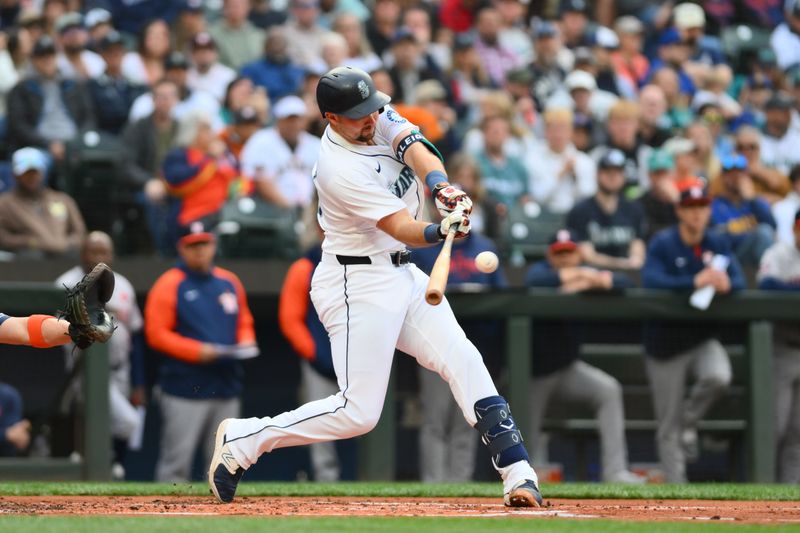 May 27, 2024; Seattle, Washington, USA; Seattle Mariners catcher Cal Raleigh (29) hits an RBI sacrifice fly ball against the Houston Astros during the first inning at T-Mobile Park. Mandatory Credit: Steven Bisig-USA TODAY Sports