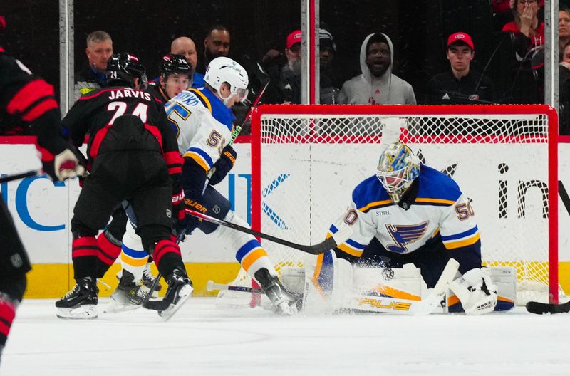 Jan 6, 2024; Raleigh, North Carolina, USA; St. Louis Blues goaltender Jordan Binnington (50) stops the scoring attempt by Carolina Hurricanes center Seth Jarvis (24) during the second period at PNC Arena. Mandatory Credit: James Guillory-USA TODAY Sports