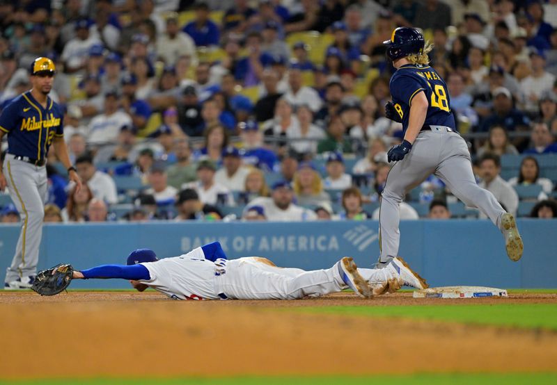 Aug 16, 2023; Los Angeles, California, USA;  Milwaukee Brewers center fielder Joey Wiemer (28) is out at first as Los Angeles Dodgers first baseman Freddie Freeman (5) reaches for a wide throw by third baseman Max Muncy (13) in the fifth inning at Dodger Stadium. Mandatory Credit: Jayne Kamin-Oncea-USA TODAY Sports