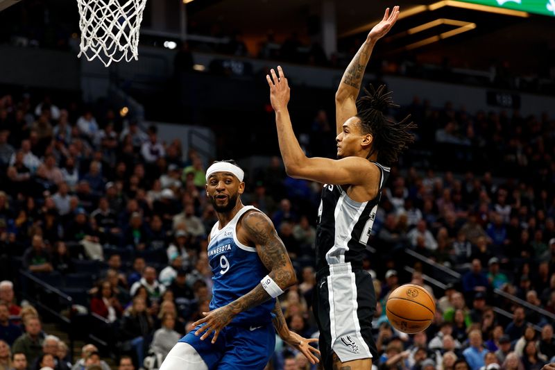 MINNEAPOLIS, MINNESOTA - FEBRUARY 27: Nickeil Alexander-Walker #9 of the Minnesota Timberwolves passes the ball against Devin Vassell #24 of the San Antonio Spurs in the first quarter at Target Center on February 27, 2024 in Minneapolis, Minnesota. NOTE TO USER: User expressly acknowledges and agrees that, by downloading and or using this photograph, User is consenting to the terms and conditions of the Getty Images License Agreement. (Photo by David Berding/Getty Images)