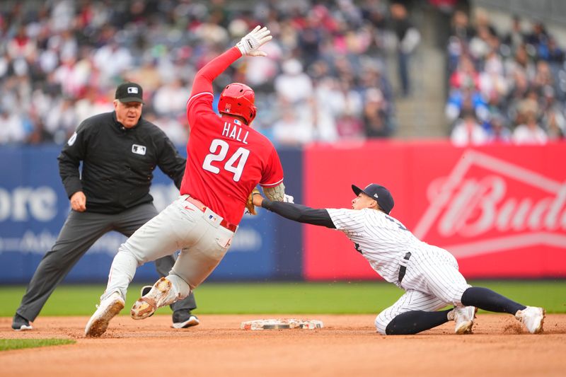 Apr 5, 2023; Bronx, New York, USA; New York Yankees shortstop Anthony Volpe (11) tags out Philadelphia Phillies first baseman Darick Hall (24) trying to stretch a single into a double during the fourth inning at Yankee Stadium. Mandatory Credit: Gregory Fisher-USA TODAY Sports