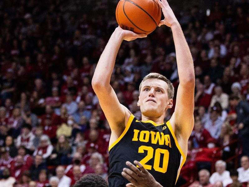 Jan 30, 2024; Bloomington, Indiana, USA; Iowa Hawkeyes forward Payton Sandfort (20) shoots the ball while Indiana Hoosiers guard Xavier Johnson (0) defends in the second half at Simon Skjodt Assembly Hall. Mandatory Credit: Trevor Ruszkowski-USA TODAY Sports