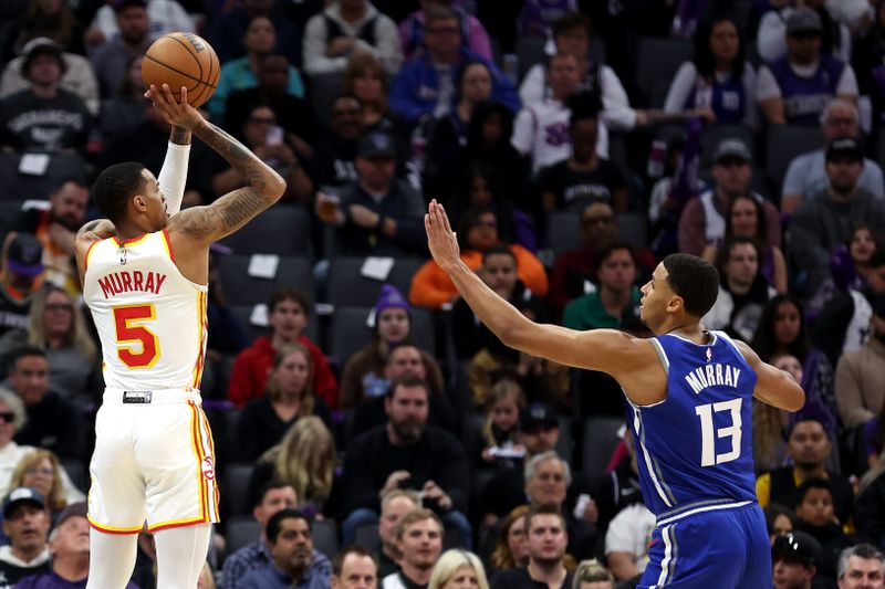 SACRAMENTO, CALIFORNIA - JANUARY 22: Dejounte Murray #5 of the Atlanta Hawks shoots over Keegan Murray #13 of the Sacramento Kings in the first half at Golden 1 Center on January 22, 2024 in Sacramento, California. NOTE TO USER: User expressly acknowledges and agrees that, by downloading and or using this photograph, User is consenting to the terms and conditions of the Getty Images License Agreement.  (Photo by Ezra Shaw/Getty Images)