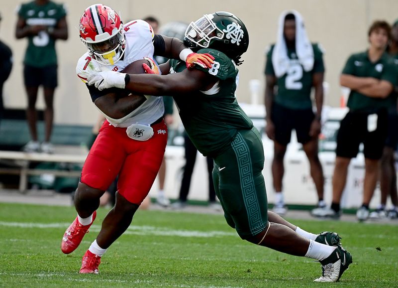 Sep 23, 2023; East Lansing, Michigan, USA;  Maryland Terrapins running back Antwain Littleton II (7) and Michigan State Spartans defensive lineman Simeon Barrow Jr. (8) collide in the third quarter at Spartan Stadium. Mandatory Credit: Dale Young-USA TODAY Sports