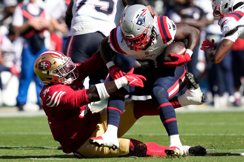 San Francisco 49ers defensive tackle Sam Okuayinonu, left, tackles New England Patriots running back Rhamondre Stevenson during the second half of an NFL football game in Santa Clara, Calif., Sunday, Sept. 29, 2024. (AP Photo/Godofredo A. Vásquez)