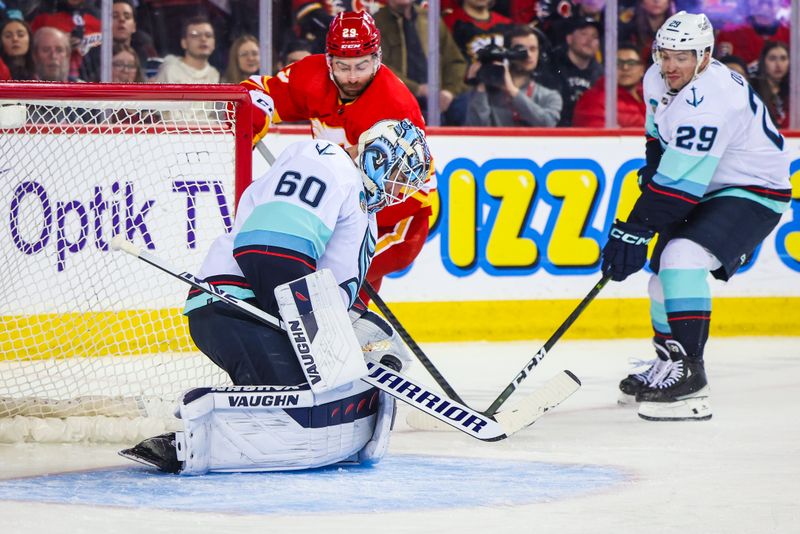 Dec 27, 2023; Calgary, Alberta, CAN; Seattle Kraken goaltender Chris Driedger (60) makes a save against Calgary Flames center Dillon Dube (29) during the second period at Scotiabank Saddledome. Mandatory Credit: Sergei Belski-USA TODAY Sports