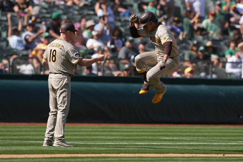 Sep 17, 2023; Oakland, California, USA; San Diego Padres left fielder Juan Soto (right) celebrates with third base coach Matt Williams (18) while rounding the bases after hitting a home run against the Oakland Athletics during the seventh inning at Oakland-Alameda County Coliseum. Mandatory Credit: Darren Yamashita-USA TODAY Sports