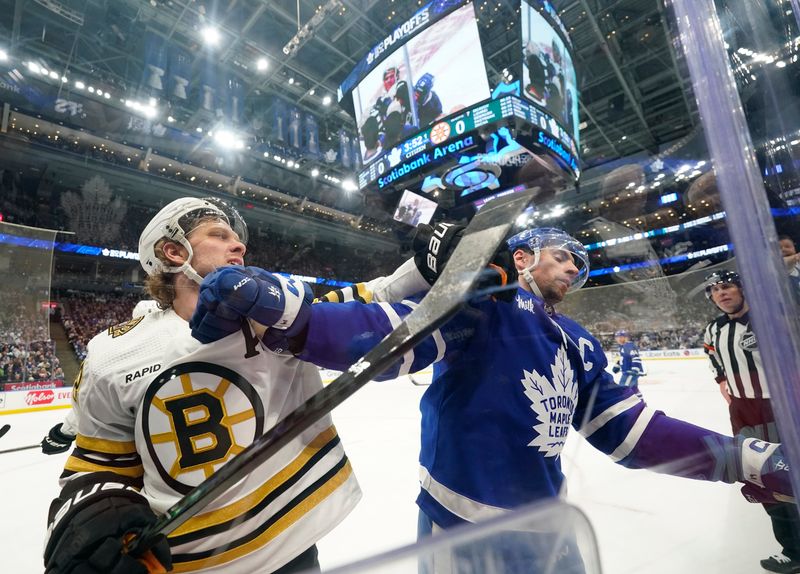 Apr 24, 2024; Toronto, Ontario, CAN; Boston Bruins forward David Pastrnak (88) and Toronto Maple Leafs forward John Tavares (91) battle along the boards during the first period of game three of the first round of the 2024 Stanley Cup Playoffs at Scotiabank Arena. Mandatory Credit: John E. Sokolowski-USA TODAY Sports